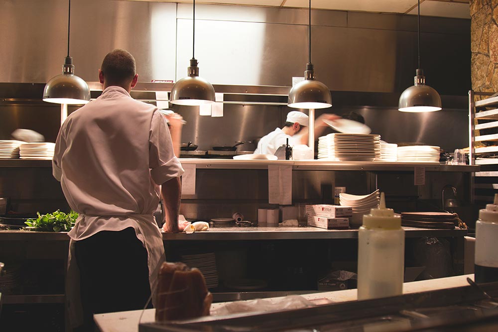 Photo of Hotel Kitchen with several Chefs cooking
